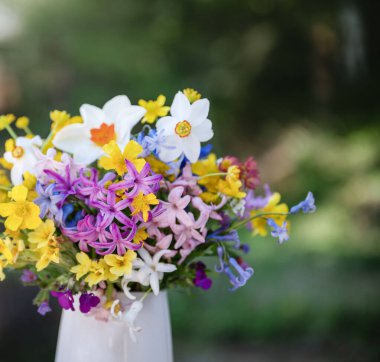 Bahar çiçeklerinin olduğu cam vazo. 