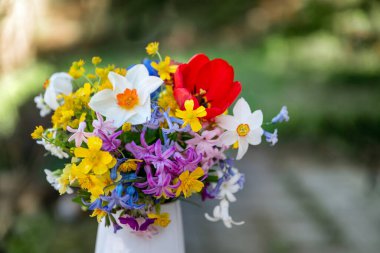 Bahar çiçeklerinin olduğu cam vazo. 