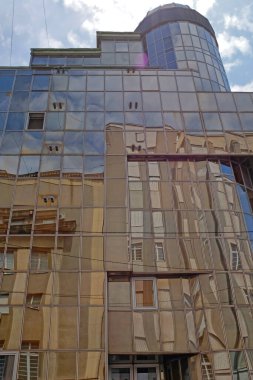 Yeni kahverengi cam gökdelendeki eski binaların mimari cam yansımaları