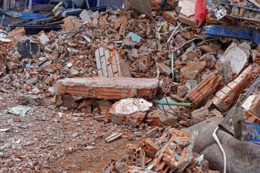 Büyük bir inşaat atığı yığını çöpleri atıyor.