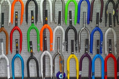 Athens, Greece - May 02, 2015: Front street bicycles forks in various colors at wall in bike shop.