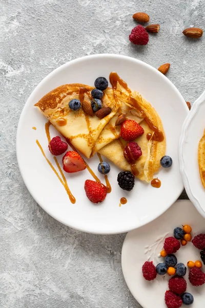 Overhead view of french crepes with berries  food on light surface