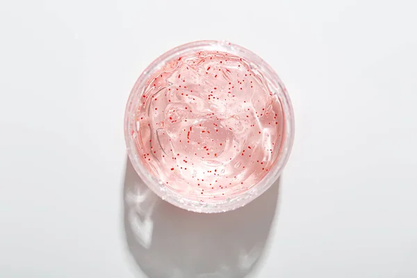 Draufsicht Auf Transparentes Gesichtsgel Mit Roten Peelingpartikeln Glas Auf Heller — Stockfoto