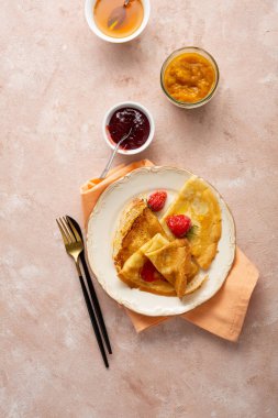 Fransız krepleri ve böğürtlenler pembe yüzeyde sıkışıyor.