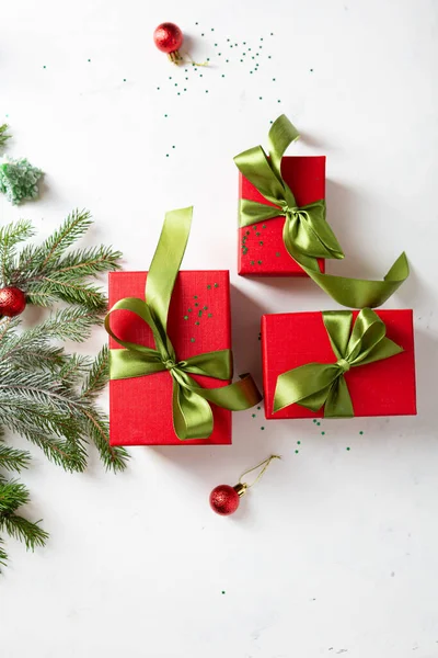 红色圣诞礼盒 绿色蝴蝶结 冷杉枝条 顶视图 — 图库照片