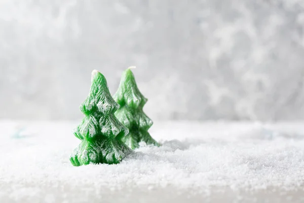 雪地上的两根绿色圣诞树蜡烛的概念复制空间 — 图库照片