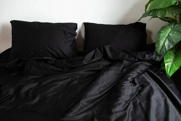 Black satin bed clothes white wall two pillow