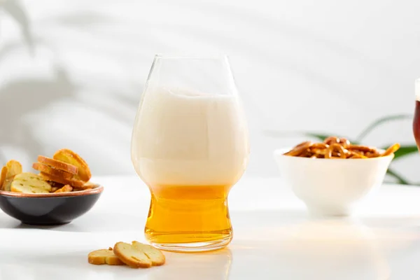 Ein Glas Bernsteinfarbenes Bier Auf Weißem Tisch Und Snacks — Stockfoto
