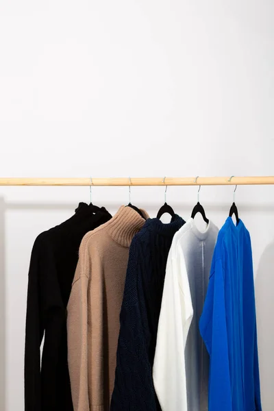 Wool sweaters jumpers  hanging on a wooden hanger cozy clothing
