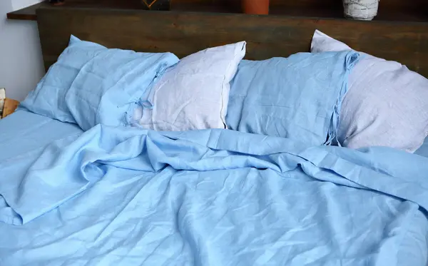 pillows on the bed white and blue linen set
