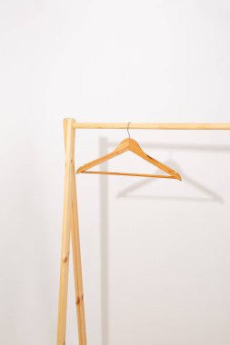 Beyaz duvar satışının yanındaki ahşap askılar.