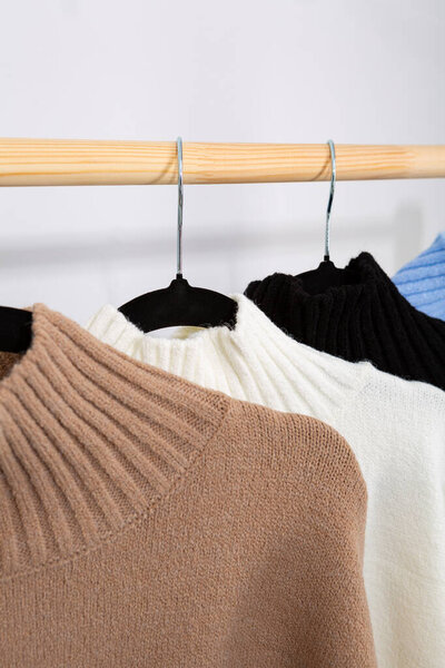 Close up of Warm wool sweaters with a stand-up collar hang on a trempel