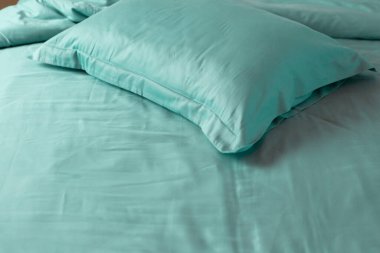 Dağınık yatak, nane, pamuk, buruşuk kumaş, mavi giysiler.