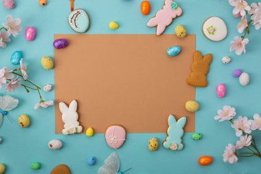 Mavi yüzey üzerinde Paskalya kokulu yumurta ve tavşan kurabiyeleri fotokopi alanı