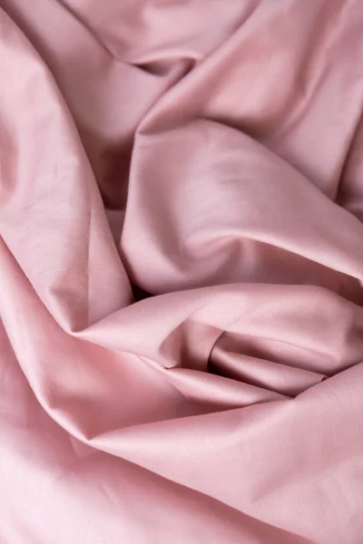pink satin fabric rolled into a ball
