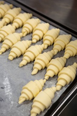 Pişirmek için bir sıra pişmemiş kruvasan