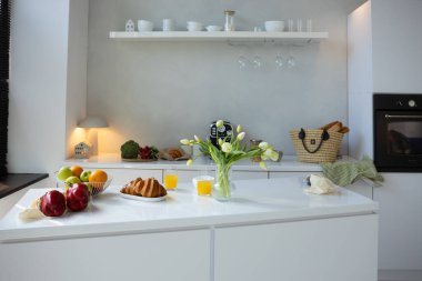 Beyaz mutfak ve kahvaltı meyveli kruvasan masa sabah rutin konsepti. 