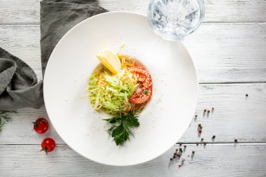 Beyaz kasede limonlu lahana salatası ve rustiac masası.