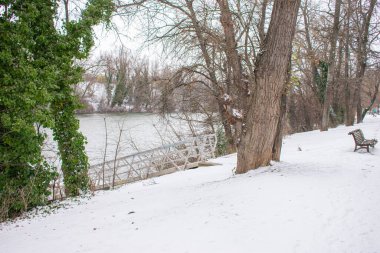 Kışın karlı bir nehir kenarı parkı