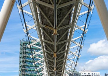 Metal bir yaya köprüsü nehrin üzerinde.