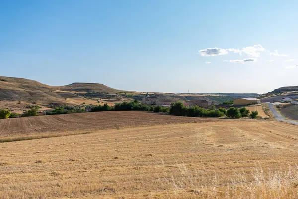 Mavi gökyüzünün altındaki köyde bir Roma Katolik taş kilisesi.