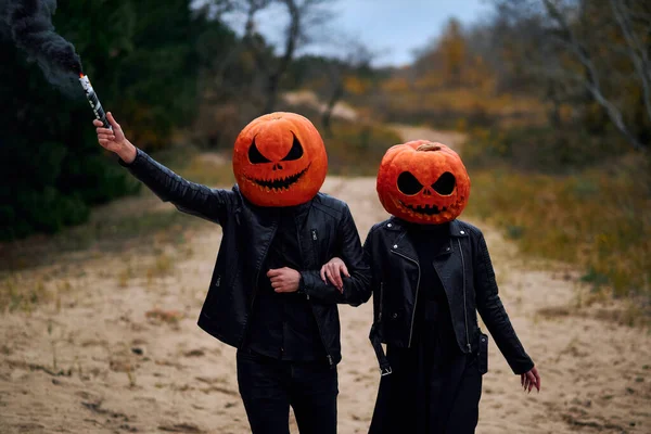 stock image Halloween boy and girl with pumpkins on their heads