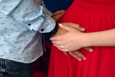 Erkek ve hamile kız el ele tutuşuyorlar.