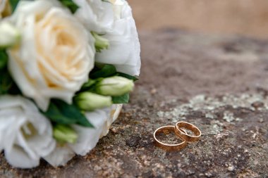 Arka planda alyans ve buket var.