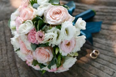 Arka planda alyans ve buket var.