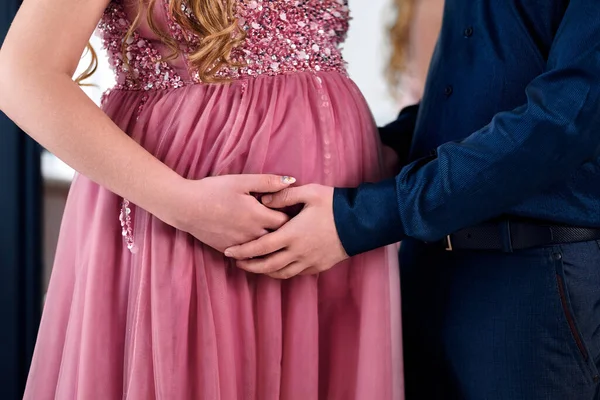 男孩和怀孕的女孩手拉手在肚子上 — 图库照片