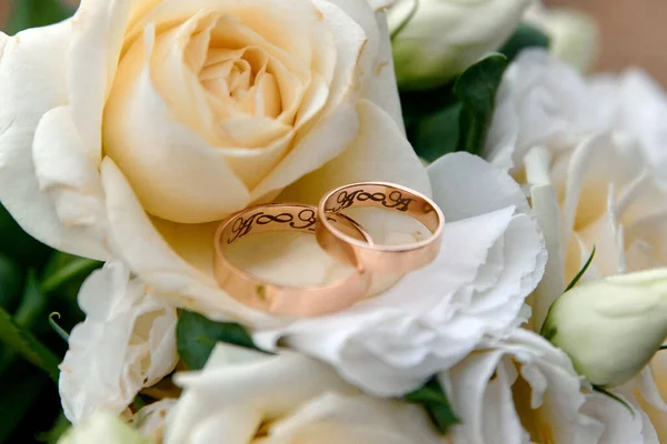 Wedding rings and bouquet on background