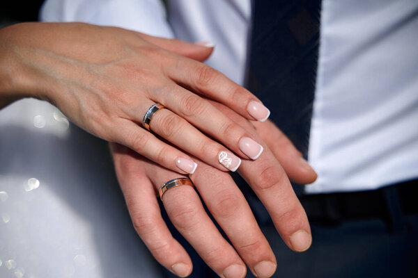 Обручальные кольца на руках крупным планом