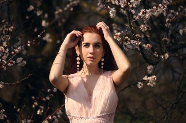 Çiçek açan bahçelerde elbiseli bir kız.