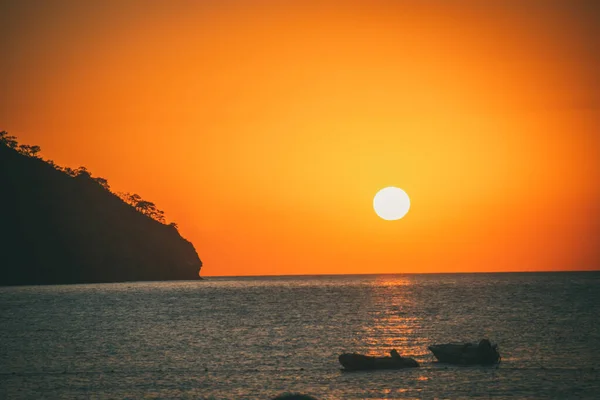 Orange sunset above sea with boat amazing Golden reflection of the sun on the calm waves. Summer landscape with sun and sea in Turkey