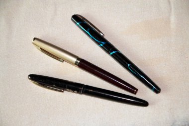 Hafif arka planda altın tüyü olan klasik mürekkep kalemi