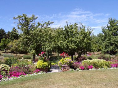 Yaz parkı manzarası Ağaçlar ve çiçek yataklarıyla