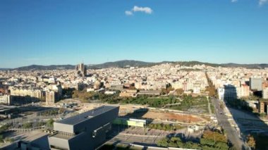 Aerial panoramic view of cityscape with Torre Glories or Torre Agbar famous modern design skyscraper and in the distance famous basilica Sagrada Familia located in Barcelona, Catalonia, Spain