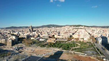 Aerial panoramic view of cityscape with Torre Glories or Torre Agbar famous modern design skyscraper and in the distance famous basilica Sagrada Familia located in Barcelona, Catalonia, Spain
