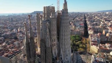 Aerial scenic view of of Barcelona City Skyline with Sagrada Familia Catholic Cathedral designed by Catalan architect Antoni Gaudi is landmark of Eixample residential district with buildings. Spain.