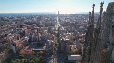 Scenic panoramic drone view of architecture from Sagrada Familia Catholic Cathedral church from the height in Barcelona. An aerial drone view of residential buildings in the city. Catalonia, Spain.