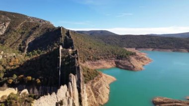 İspanya 'nın Huesca bölgesindeki Canyelles rezervuarının kıyısındaki Finestras yerleşim olmayan köyünün yakınlarındaki Çin Duvarı' nın güzel manzaralı keskin kayaları üzerinde uçan insansız hava aracı görüntüsü. 4K video
