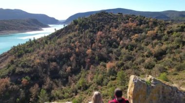 Kenar Canyelles rezervuar turkuaz gölündeki turistler üzerinde panoramik hava aracı uçuşu, Huesca ili, Katalonya ve Aragon sınırında yer alan muhteşem doğal manzara. 4K