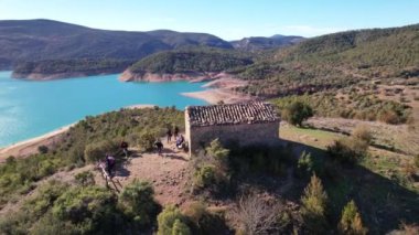 Kenar Canyelles rezervuar turkuaz gölündeki turistler üzerinde panoramik hava aracı uçuşu, Huesca ili, Katalonya ve Aragon sınırında yer alan muhteşem doğal manzara. 4K