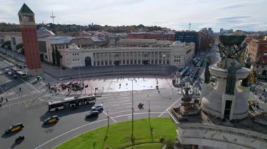 Barcelona 'nın Squares kentindeki Plaza de Espana meydanındaki kavşakta Venedik Kuleleri ile kesişen kalabalık sokak trafiğinin ve insanların hava görüntüsü Barcelona' nın en önemli meydanlarından biridir. 4K