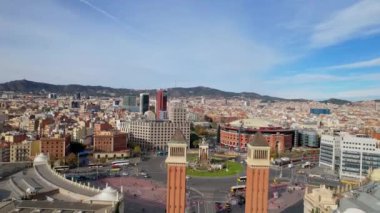 Venedik Kuleleri ve Barcelona Arenas de Barcelona ile Barcelona 'daki Squares' li Plaza de Espana şehir trafiğinin panoramik hava aracı görüntüsü. Placa de Espanya 'nın muazzam çeşmesinde arabalar dolanıyor. 4K video