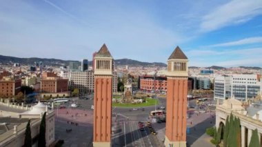 Venedik Kuleleri ve Arenas de Barcelona ile Squares 'li Plaza de Espana şehir trafiğinin uzun panoramik hava aracı görüntüsü. Barcelona 'daki Venedik Kuleleri arasında uçan insansız hava aracı. Katalonya, İspanya. 4K video