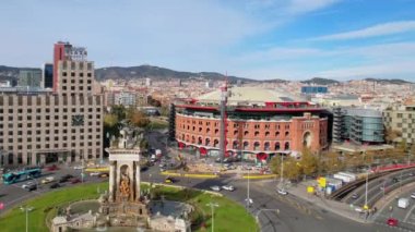 Venedik Kuleleri ve Barcelona Arenas de Barcelona ile Barcelona 'daki Squares' li Plaza de Espana şehir trafiğinin panoramik hava aracı görüntüsü. Placa de Espanya 'nın muazzam çeşmesinde arabalar dolanıyor. 4K video