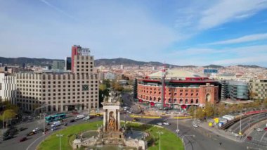 Barcelona 'daki Plaza de Espana şehrinin havadan görünüşü Barcelona' nın en önemli meydanlarından ve Arenas de Barcelona 'dır. Placa de Espanya 'nın muazzam çeşmesinde arabalar dolanıyor. 4K video