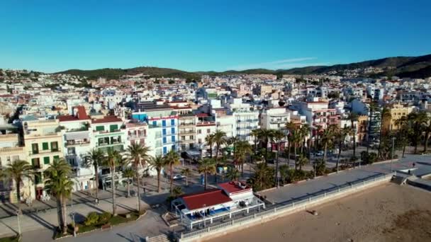西班牙加泰罗尼亚巴塞罗那市附近小镇上阳光明媚的Sant Bartomeu Santa Tecla Sitges沿海村全景无人驾驶飞机图像 它以其海滩和夜生活而闻名 — 图库视频影像