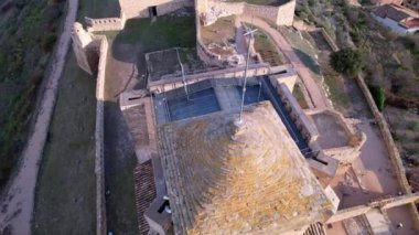 Benabarre 'ın eski ortaçağ şatosunun panoramik hava aracı görüntüsü, taştan yapılmış ve küçük boşluklarla yapılmış, Ribagorza Kalesi. Huesca Bölgesi, Aragon, İspanya. 4K video